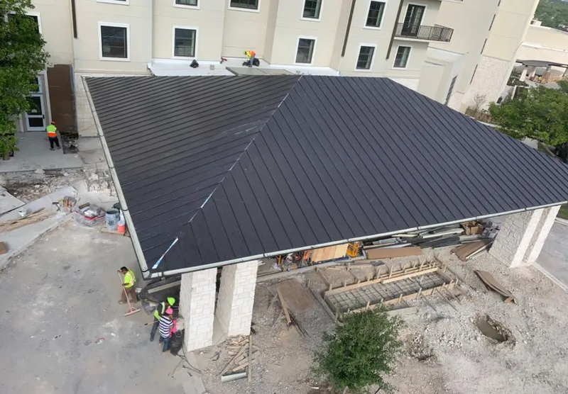Metal roofing installation team working on a commercial building in Kenner